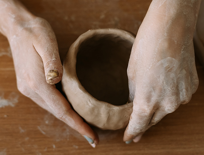 hands making a ceramic pot